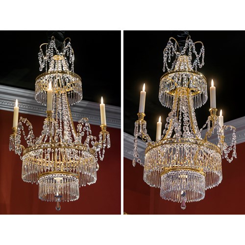 A pair of neoclassical crystal, brass and bronze chandeliers